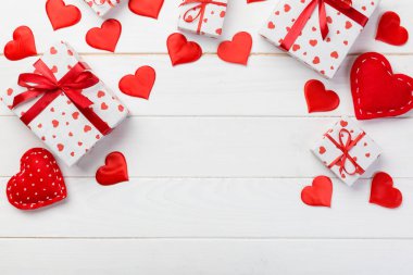 Sevgililer veya diğer tatil el yapımı mevcut kağıt ile tatil sarmalayıcı kırmızı kalpler ve hediye kutusunda. Tasarım için kopya alanı görünümüyle Beyaz ahşap masa üstü, boş alanı kutusu hediye sunmak.