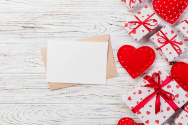 Beyaz ahşap arka plan üzerinde kırmızı kalp ve hediye kutusu ile zarf posta. Sevgililer günü kartı, aşk veya kavramı tebrik düğün.