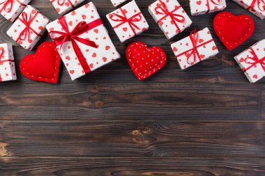 Sevgililer veya diğer tatil el yapımı mevcut kağıt ile tatil sarmalayıcı kırmızı kalpler ve hediye kutusunda. Tasarım için kopya alanı görünümüyle koyu ahşap masa üstü, boş alanı hediye kutusu.