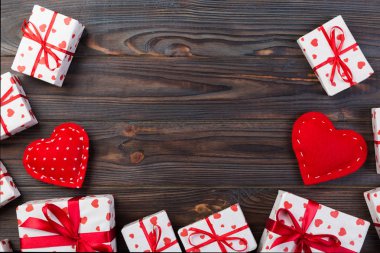 Sevgililer veya diğer tatil el yapımı mevcut kağıt ile tatil sarmalayıcı kırmızı kalpler ve hediye kutusunda. Tasarım için kopya alanı görünümüyle koyu ahşap masa üstü, boş alanı hediye kutusu.