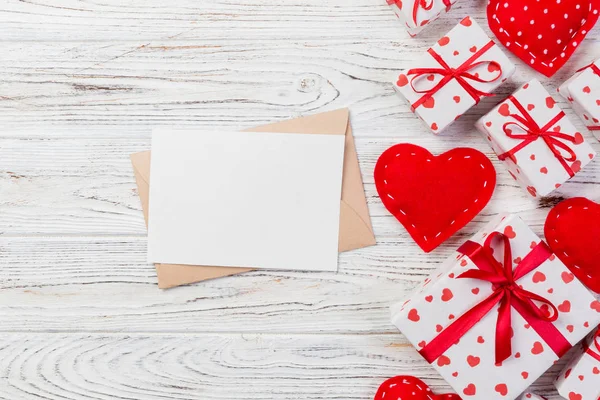 Beyaz ahşap arka plan üzerinde kırmızı kalp ve hediye kutusu ile zarf posta. Sevgililer günü kartı, aşk veya kavramı tebrik düğün.