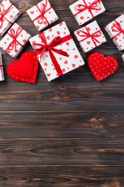 Sevgililer veya diğer tatil el yapımı mevcut kağıt ile tatil sarmalayıcı kırmızı kalpler ve hediye kutusunda. Tasarım için kopya alanı görünümüyle koyu ahşap masa üstü, boş alanı hediye kutusu.