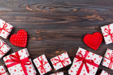 Sevgililer veya diğer tatil el yapımı mevcut kağıt ile tatil sarmalayıcı kırmızı kalpler ve hediye kutusunda. Tasarım için kopya alanı görünümüyle koyu ahşap masa üstü, boş alanı hediye kutusu.