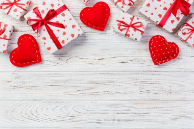 Sevgililer veya diğer tatil el yapımı mevcut kağıt ile tatil sarmalayıcı kırmızı kalpler ve hediye kutusunda. Tasarım için kopya alanı görünümüyle Beyaz ahşap masa üstü, boş alanı hediye kutusu.