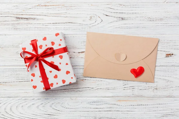 Envelope Mail with Red Heart and gift box over White Wooden Background. Valentine Day Card, Love or Wedding Greeting Concept.