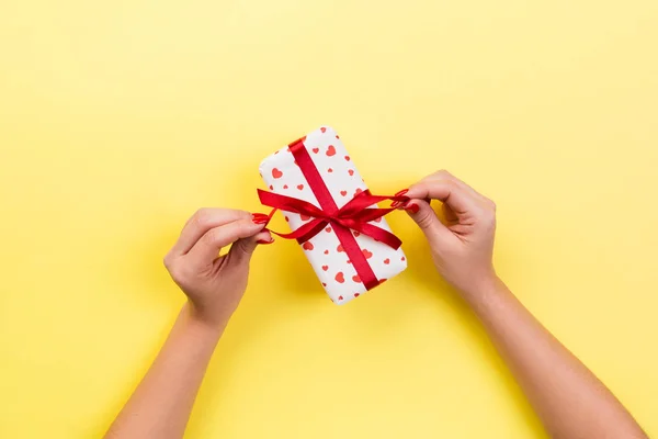 妇女的手给包装的情人节或其他节日手工礼物的纸与红色丝带 礼品的礼物盒 红色的心装饰 顶部的视图与复制空间为您设计 — 图库照片