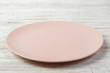 Perspektif görünümü. Akşam yemeği beyaz ahşap zemin için boş gül mat çanak.