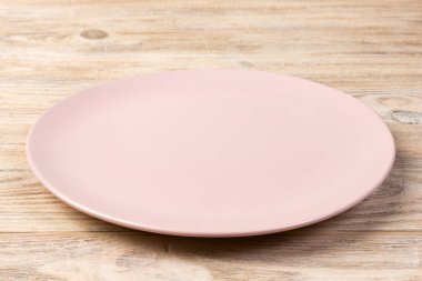 Perspektif görünümü. Turuncu ahşap arka plan boş pembe mat plaka.