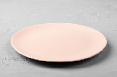 Üstten görünüm mat gri çimento arka plan kopya alanı tasarım için boş gül tabağa yuvarlak. Perspektif görünümü.