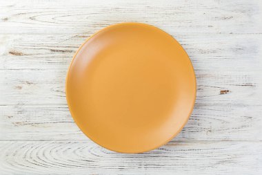 Directy boş sarı mat plaka Beyaz ahşap zemin üzerinde yukarıda.