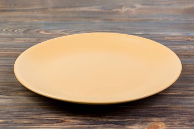 Perspektif görünümü. Koyu ahşap arka plan boş portakal mat plaka.