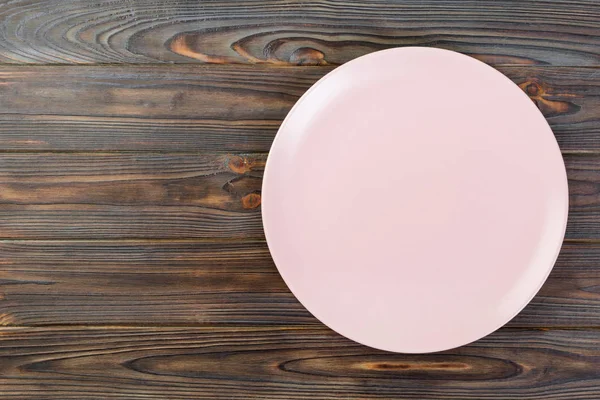 コピー スペースと暗い背景の木の夕食の空のピンク マット皿の上直接 — ストック写真
