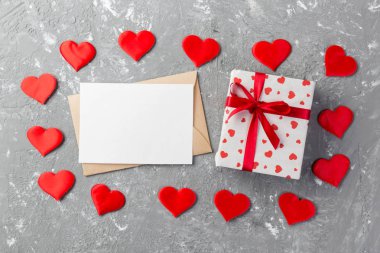 Zarf posta gri çimento arka plan üzerinde kırmızı kalp ve hediye kutulu. Sevgililer günü kartı, aşk veya kavramı tebrik düğün.