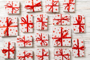 Üstten görünüm portre Sevgililer ya da diğer tatil el yapımı mevcut kağıt kırmızı kurdele ve kalp ile sarılı. Kutusu, ahşap masa üzerinde Hediyelik Dekorasyon.