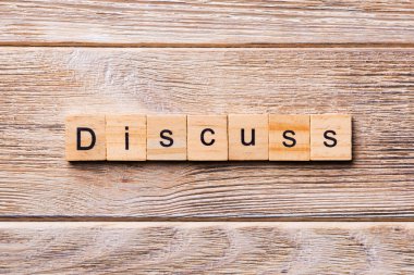 Ahşap blok üzerinde yazılı kelime tartışmak. Metin için tasarım, ahşap masa üzerinde tartışmak kavramı.