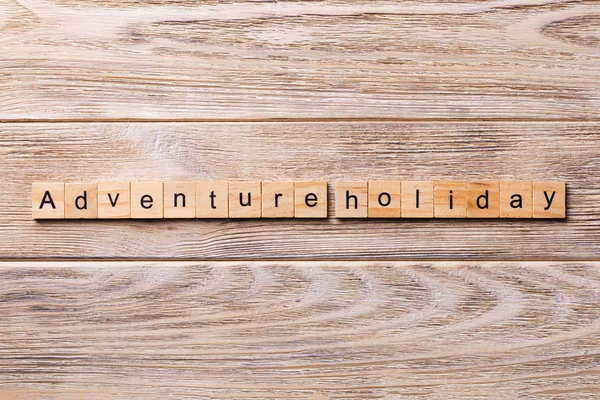 stock image adventure holiday word written on wood block. adventure holiday text on wooden table for your desing, concept.