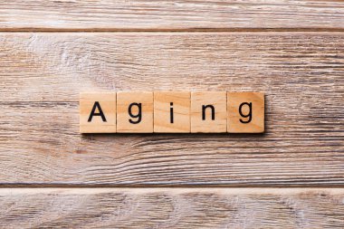 Tahta blokta yazan eski bir kelime. Ahşap masadaki eski metin desing, konsept için.