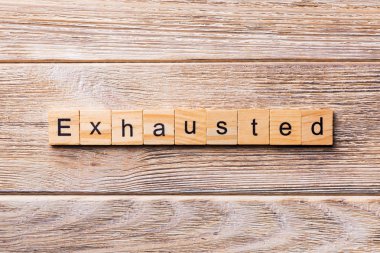 Yorgunluktan kelime ahşap blok üzerinde yazılı. Yorgunluktan metin, tasarım, ahşap masanın kavramı.