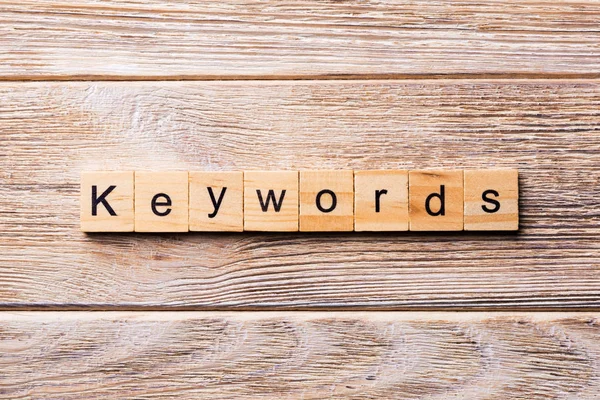 ウッド ブロックに書かれたキーワードの単語 あなたのデザインの木製のテーブル上のキーワード テキスト コンセプト — ストック写真