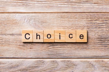 Tahta bloğa yazılmış bir kelime. Ahşap masa üzerindeki CHOICE metin desing, konsept için.