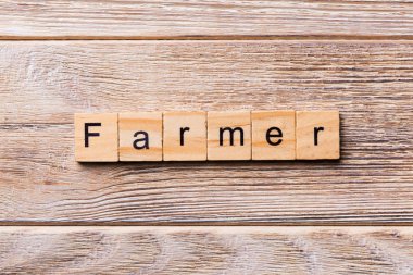 Çiftçi kelime ahşap blok üzerinde yazılı. Çiftçi metin, tasarım, ahşap masanın kavramı.