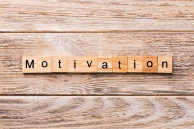 Motivasyon kelime ahşap blok üzerinde yazılı. Motivasyon metin, tasarım, ahşap masanın kavramı.