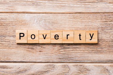Tahta blokta yazan yoksulluk kelimesi. Yoksulluk metni ahşap masa üzerinde desing için, konsept.