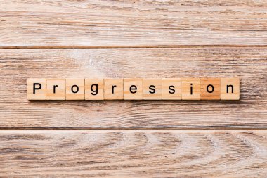 ilerleme kelime ahşap blok üzerinde yazılı. ilerleme metin, tasarım, ahşap masanın kavramı.