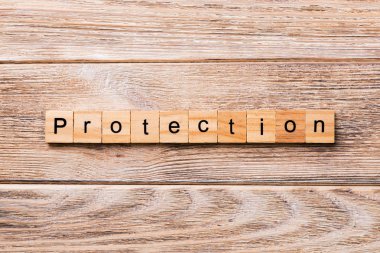 Koruma kelime ahşap blok üzerinde yazılı. Koruma metin, tasarım, ahşap masanın kavramı.