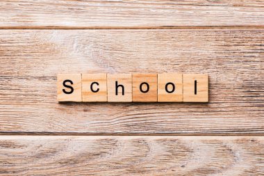 okul kelime ahşap blok üzerinde yazılı. okul için tasarım, ahşap masa üzerinde metin kavramı.