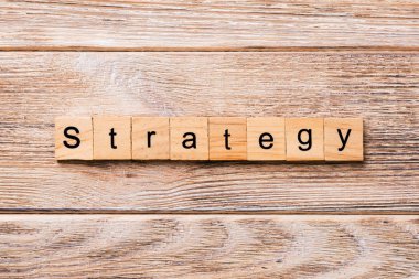 Strateji kelime ahşap blok üzerinde yazılı. Strateji metin, tasarım, ahşap masanın kavramı.