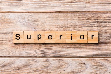 Üstün kelime ahşap blok üzerinde yazılı. Senin tasarım ahşap masanın üstün metin kavramı.