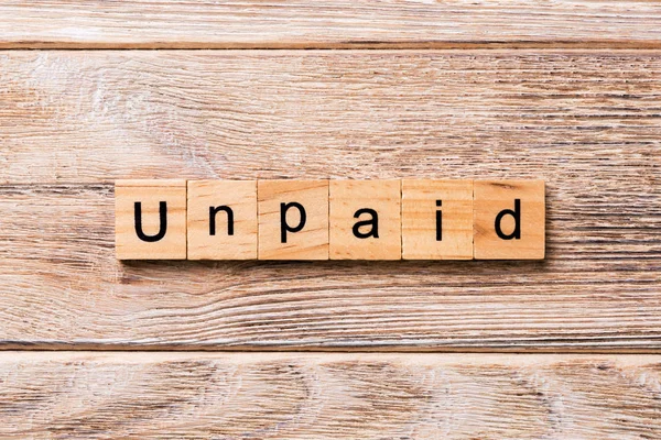 Tahta blokta ödenmemiş kelime. Ahşap masa üzerinde ödenmemiş metin desing için, konsept.