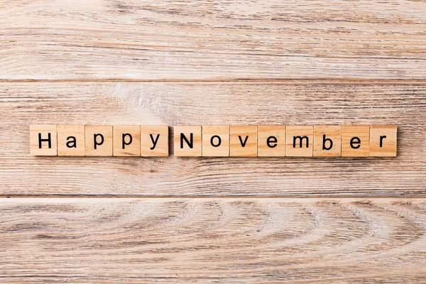 Happy november word written on wood block. Happy november text on table, concept.