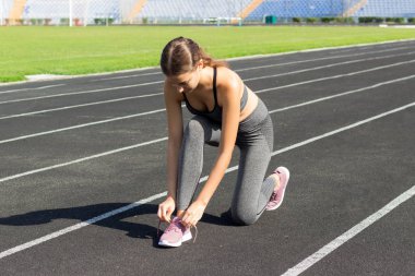 Runner Kadınlar Ayakkabı bağcıklarımı stadyum spor ve fitness kavramı çalışma yolda yarış için hazır almak bağlama.