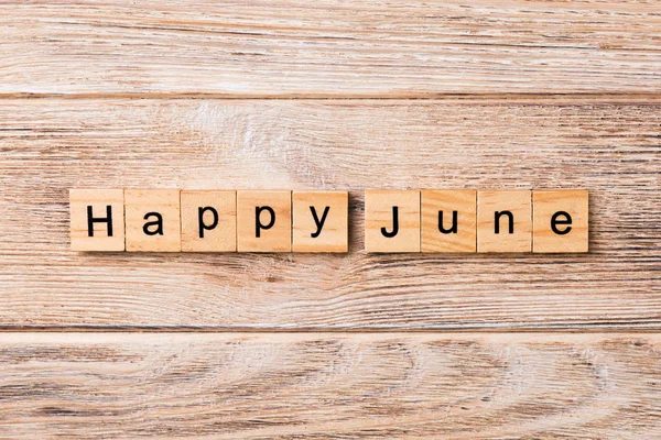 Happy June word written on wood block. Happy June text on table, concept.