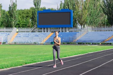 fitness stadyumda yolda çalışan bir kadın. Yaz aylarında eğitim. Spor, sağlıklı yaşam biçimi kavramı.