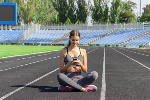 Una Hermosa Chica Fitness Ropa Deportiva Gris Utiliza Teléfono Inteligente — Foto de Stock