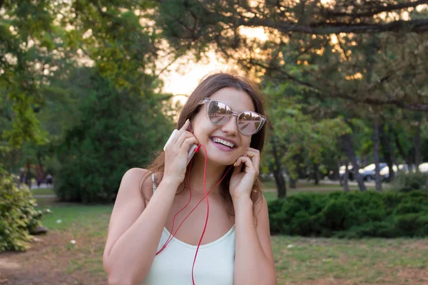 Güzel kız kulaklık dışında müzik dinliyor. En sevdiğin şarkı. Kadın parkta dinlenme geçiriyor