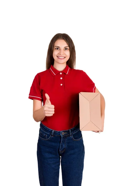 Молода красива жінка тримає коробку для посилок, вказуючи великий палець вгору ізольовано на білому тлі — стокове фото