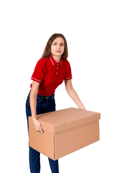 Dziewczyna dostawa zmęczony jest holing ciężka paczka pudełko kartonowe na białym tle — Zdjęcie stockowe