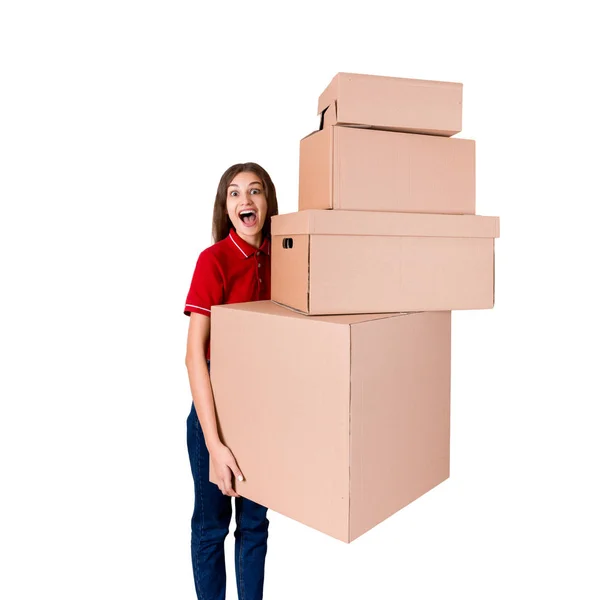 Счастливая молодая женщина в красной футболке держит стопку больших коробок посылок, изолированных на белом фоне — стоковое фото