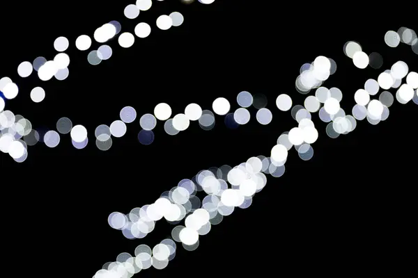 Bokeh branco abstrato sem foco no fundo preto. desfocado e desfocado muitos luz redonda — Fotografia de Stock
