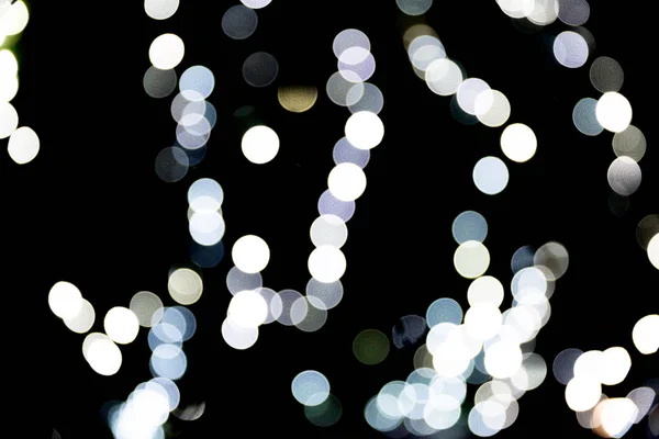 Bokeh abstrato de luzes brancas da cidade sobre fundo preto. desfocado e desfocado muitos luz redonda — Fotografia de Stock