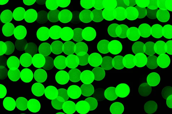 Rozostřený bokeh abstraktní zelená na černém pozadí. rozostření a rozmazané n kulaté světlo — Stock fotografie