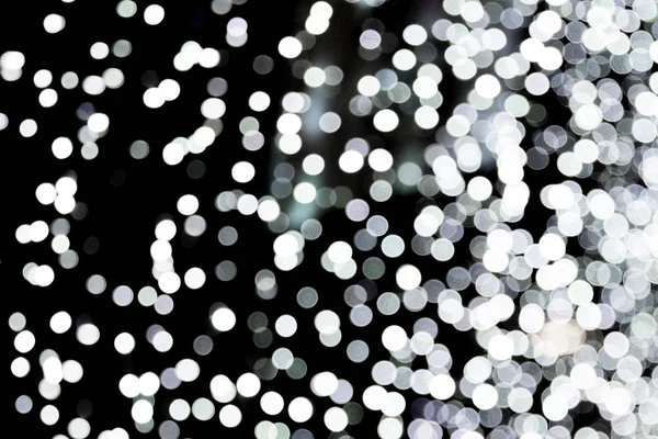 Bokeh abstrato de luzes brancas da cidade sobre fundo preto. desfocado e desfocado muitos luz redonda — Fotografia de Stock