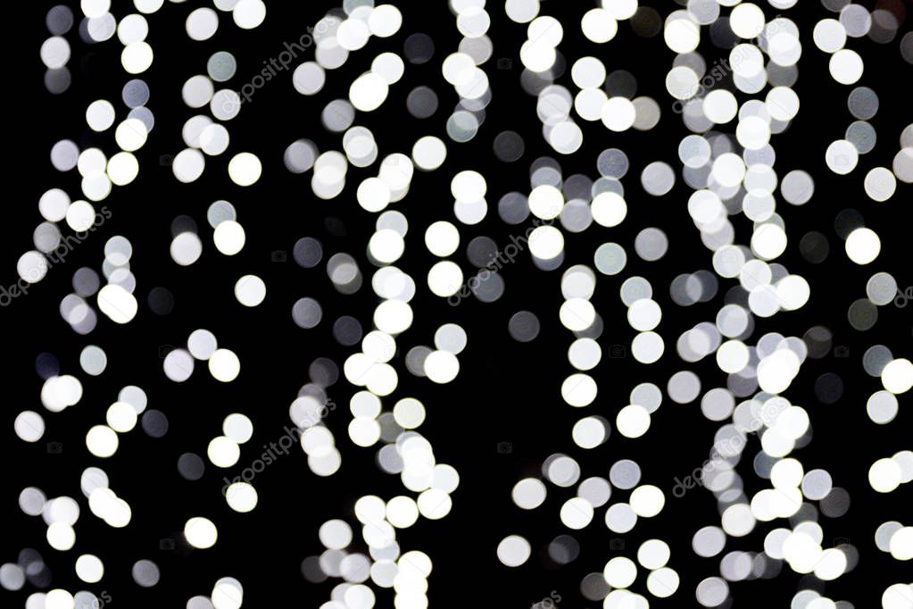 Abstract bokeh of white lights on black background. defocused and blurred many round light