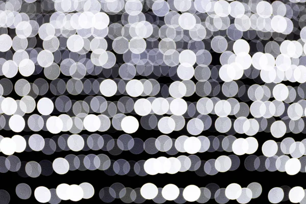 Bokeh abstrato de luzes brancas da cidade sobre fundo preto. desfocado e desfocado muitos luz redonda — Fotografia de Stock