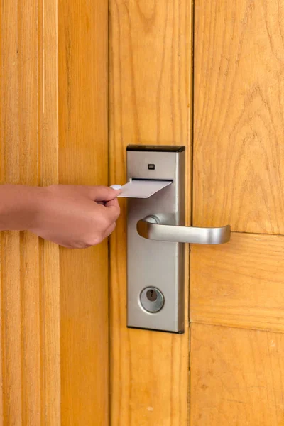 Mano de mujer con llave en la cerradura electrónica. tarjeta llave de mano femenina y puerta de cerradura electrónica abierta —  Fotos de Stock