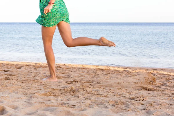 Bein einer Frau läuft am Sandstrand. Sommerferien. glücklich schöne Frau läuft am Strand — Stockfoto